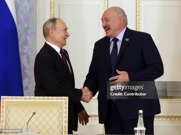 Russian President Vladimir Putin and Belarussian President Alexander Lukashenko smile during the plenary session of the Supreme Council of Russia and...