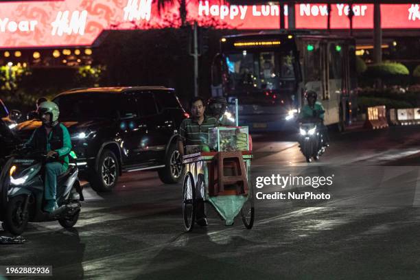 Street vendors are carrying carts and walking in the business district during rush hours in Jakarta, Indonesia, on January 29, 2024. Secretary of the...