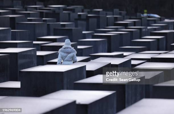 Woman walks among stelae at the Memorial to the Murdered Jews of Europe, also called the Holocaust Memorial, on the eve of International Holocaust...