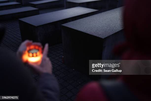 Local people arriving with candles approach stelae at the Memorial to the Murdered Jews of Europe, also called the Holocaust Memorial, on the eve of...