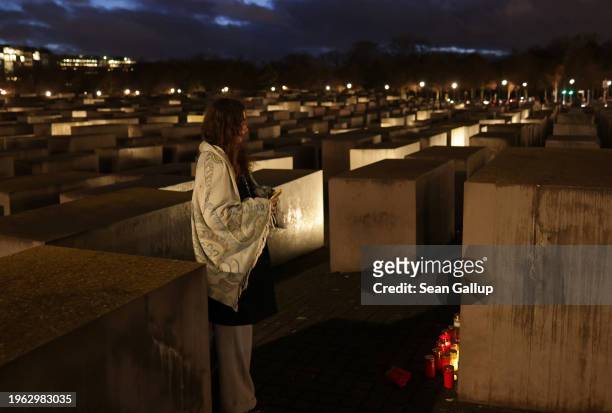 Young woman who said she is originally from Israel but now lives in Berlin stands at candles among stelae at the Memorial to the Murdered Jews of...