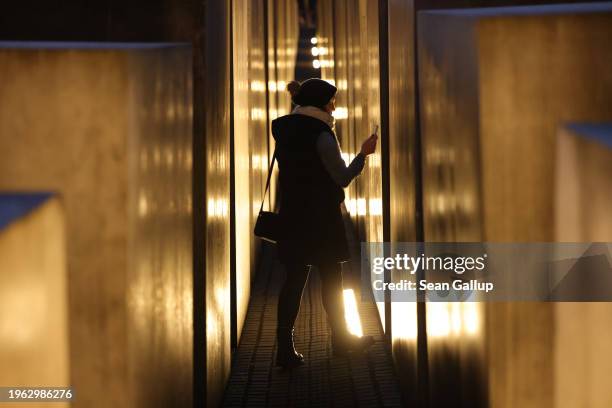 Visitor walk among illuminated stelae at the Memorial to the Murdered Jews of Europe, also called the Holocaust Memorial, on the eve of International...