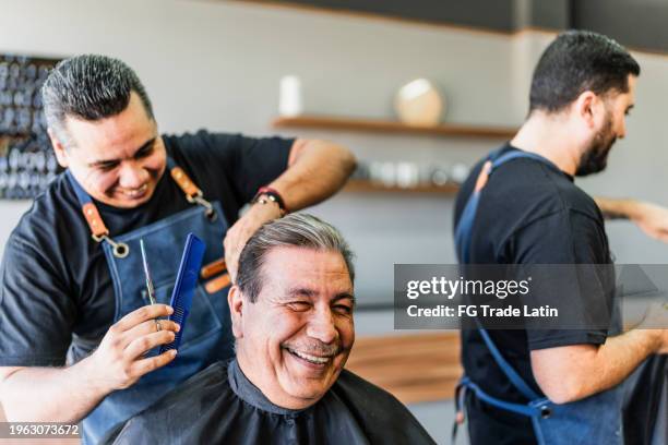 barber cutting his customer hair at barber shop - barbier stockfoto's en -beelden