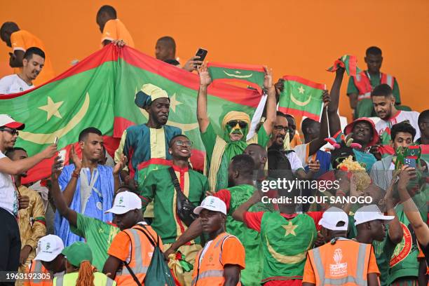 Mauritania's supporters hold Mauritanian flags ahead of the Africa Cup of Nations 2024 round of 16 football match between Cape Verde and Mauritania...