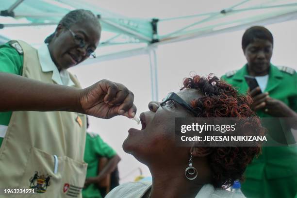 Nurse administers a dosage of the cholera vaccine during the launch of the campaign to immunise people in affected areas, at the Kuwadzana Polyclinic...