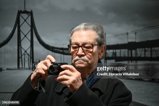 Portuguese photojournalist Eduardo Gageiro takes pictures while standing in front of one of his iconic photos on the opening day of "Factum", his...