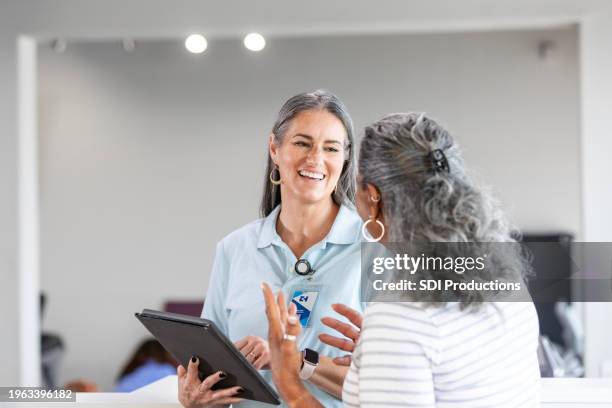therapeutin dokumentiert symptome einer seniorin auf digitalem tablet - ambulante behandlung stock-fotos und bilder