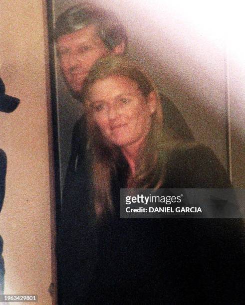 The Duchess of York Sarah Ferguson is escorted by an unidentified man 21 September as she walks through a VIP room after her arrival at Buenos Aires'...
