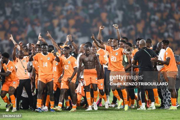 Ivory Coast's players celebrate after the victory at the end of the Africa Cup of Nations 2024 round of 16 football match between Senegal and Ivory...