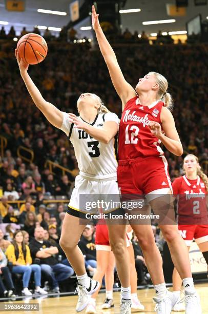 Iowa guard Sydney Affolter puts up a shot over Nebraska forward Jessica Petrie during a women's college basketball game between the Nebraska...