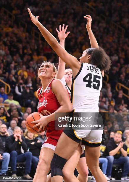 Nebraska center Alexis Markowski attempts a shot as Iowa forward Hannah Stuelke defends during a women's college basketball game between the Nebraska...