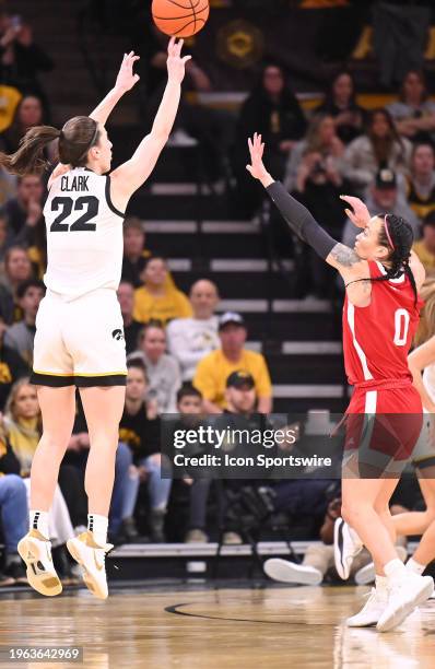 Iowa guard Caitlin Clark attempts a three-point shot over Nebraska guard Darian White during a women's college basketball game between the Nebraska...