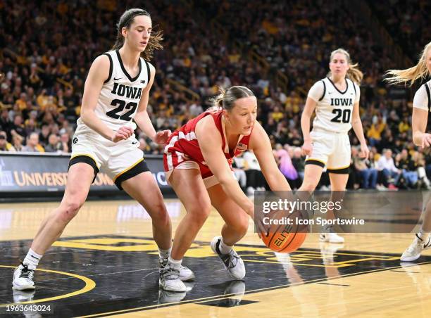 Nebraska guard Callin Hake reaches out to control a rebound as Iowa guard Caitlin Clark looks on during a women's college basketball game between the...