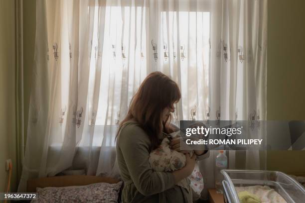 Yulia holds her newborn daughter Diana in a maternity hospital in Pokrovsk, Donetsk region, on January 24 amid the Russian invasion of Ukraine. This...