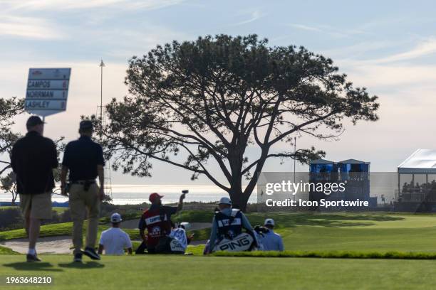 Grouping of golfers, their caddies, and entourage walk down the 16th hole fairway during the final round of the PGA Tour Farmer's Insurance Open, at...