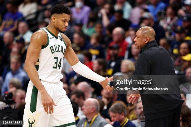 Head Coach Doc Rivers and Giannis Antetokounmpo of the Milwaukee Bucks slap high five against the Denver Nuggets at Ball Arena on January 29, 2024 in...