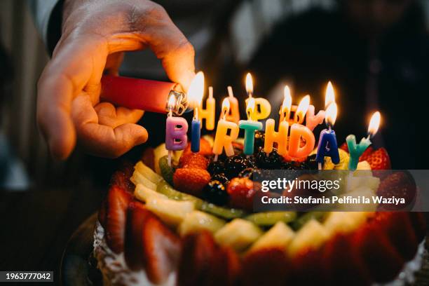 lighting happy birthday candles - geburtstagstorte stock-fotos und bilder