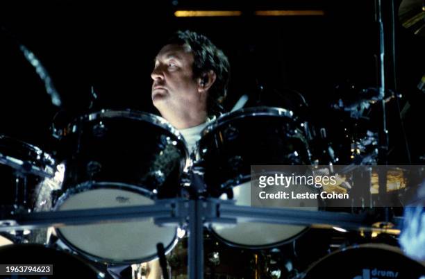English drummer Nick Mason of Pink Floyd sits behind his drum kit, circa 1990.