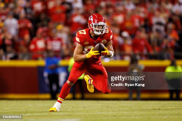 Travis Kelce of the Kansas City Chiefs runs the ball after a catch during an NFL football game against the Denver Broncos at GEHA Field at Arrowhead...