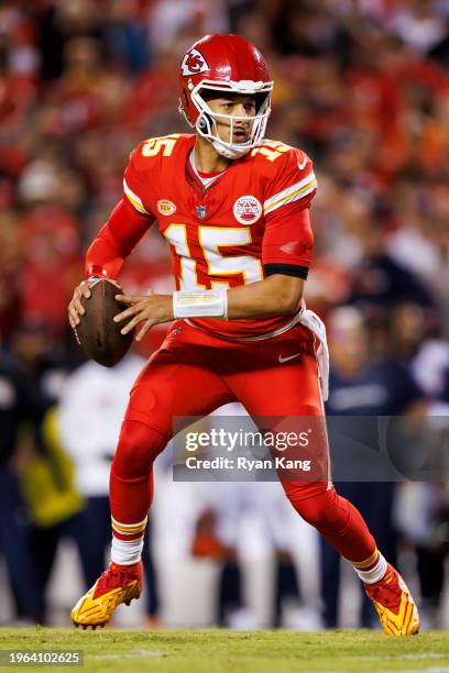 Patrick Mahomes of the Kansas City Chiefs rolls out and looks to throw a pass during an NFL football game against the Denver Broncos at GEHA Field at...