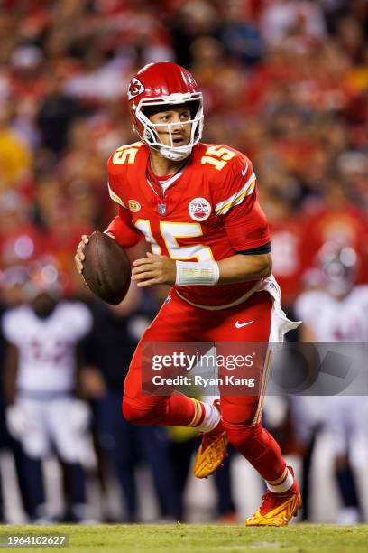 Patrick Mahomes of the Kansas City Chiefs rolls out and looks to throw a pass during an NFL football game against the Denver Broncos at GEHA Field at...