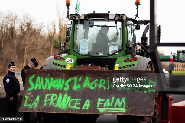 Farmer drives a tractor with a tag that says "Save the agriculture, France has hunger" during the farmers' strike. Agriculture workers block eight of...