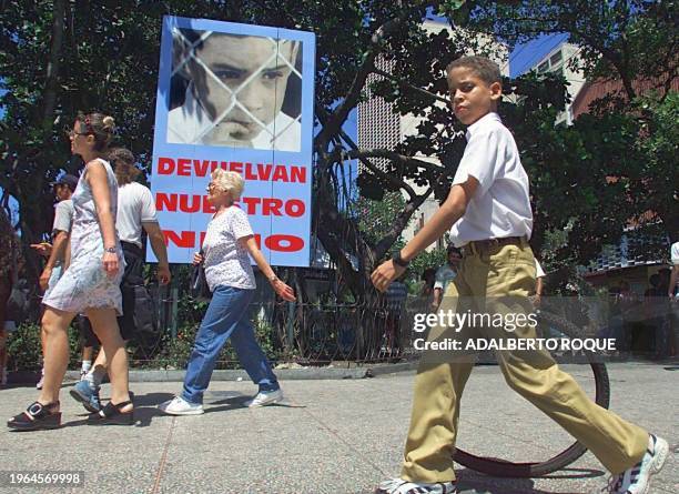 Cuban student passes in front of a poster of Elian Gonzalez, 21 March 2000 in Havana, Cuba. Un escolar cubano pasa frente a un cartel del nino cubano...