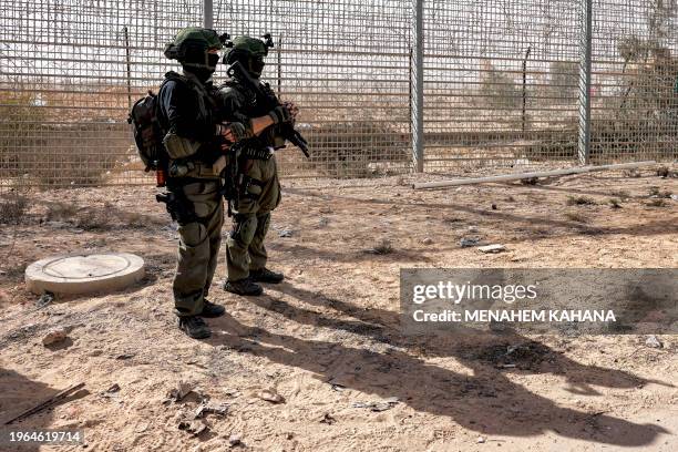 Israeli army soldiers stand guard by the border fence with Egypt at the Nitzana border crossing in southern Israel on January 30 as Israeli...