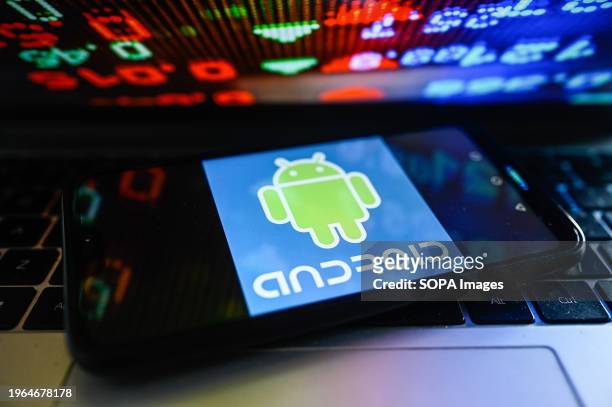 In this photo illustration, an Android logo is displayed on a smartphone with stock market percentages on the background.