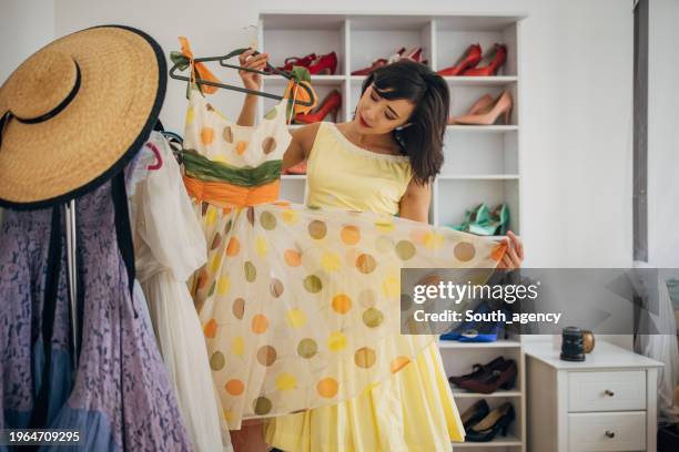 classy woman choosing dress for today - rack of dresses stock pictures, royalty-free photos & images