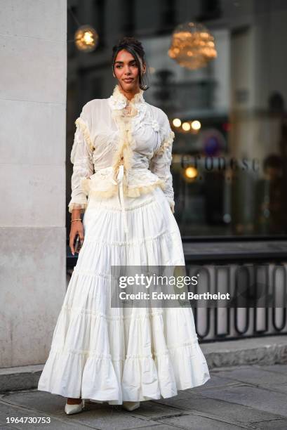 Guest wears a white lace gathered ruffled shirt with mesh parts, a gathered long skirt, pointed shoes, outside Jean Paul Gaultier, during the Haute...