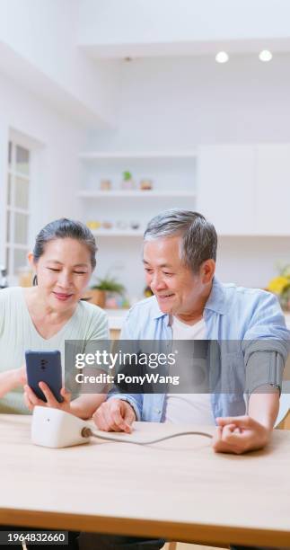 old couple test blood pressure - cuff sleeve stock pictures, royalty-free photos & images