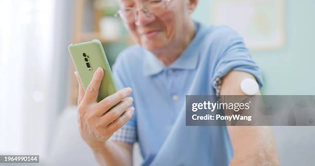 mann verwenden cgm mit handy - typ 1 diabetes stock-fotos und bilder