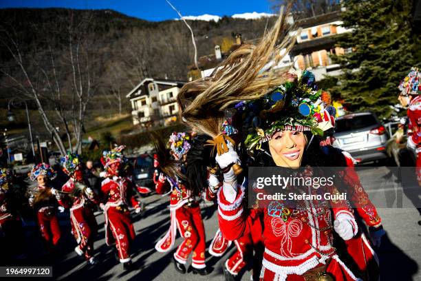 People dressed in colorful costumes and scary wooden masks, decorated with mirrors, walk during the Napoleon-themed Coumba Freida Carnival on January...