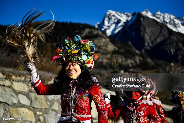 People dressed in colorful clothes and wearing scary wooden masks decorated with mirrors walks during the Napoleon-themed Coumba Freida Carnival on...