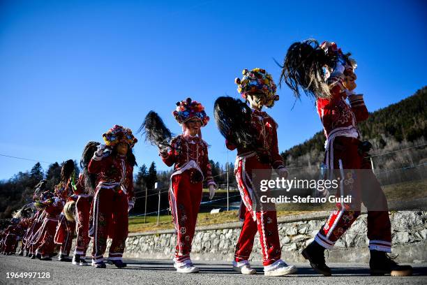 People dressed in colorful clothes and wearing scary wooden masks decorated with mirrors walks during the Napoleon-themed Coumba Freida Carnival on...