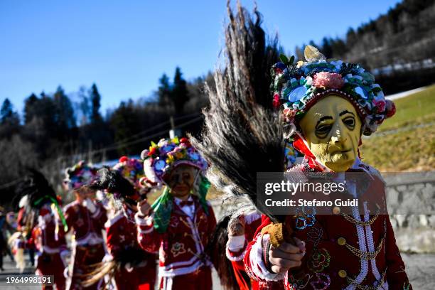 People dressed in colorful clothes and wearing scary wooden masks decorated with mirrors walks during the Napoleon-themed Coumba Freida Carnival on...