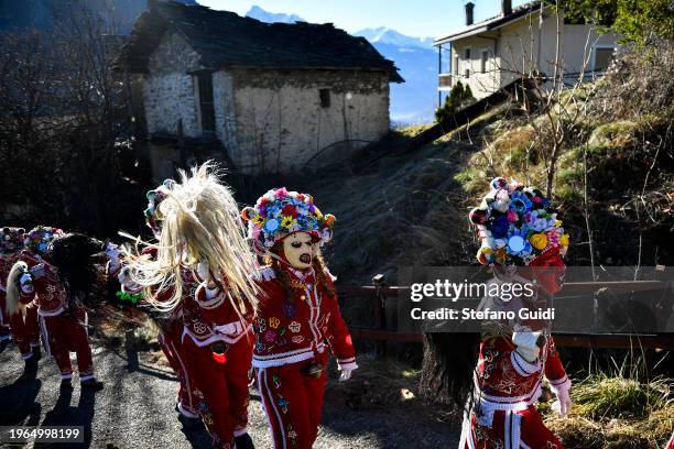 People dressed in colorful clothes and wearing scary wooden masks decorated with mirrors walks during the Napoleon-themed Coumba Freida Carnival on...