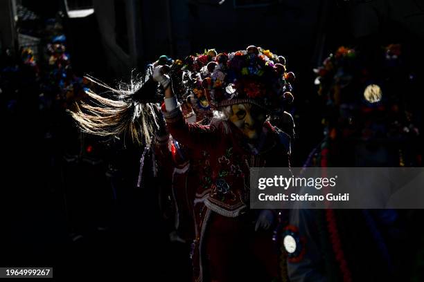 People dressed in colorful clothes and wearing scary wooden masks decorated with mirrors walks during the Napoleon-themed Coumba Freida Carnival on...