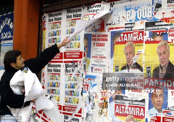 Man removes campaign posters 26 april 2003 in Buenos Aires, one day before 25.5 million voters of Argentina's population of 36 million are legally...