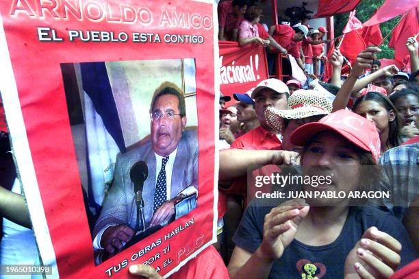 Supporter of the Liberal Constitutionalist Party applauds next to a poster of former Nicaraguan President and speaker of Nicaragua's legislature...