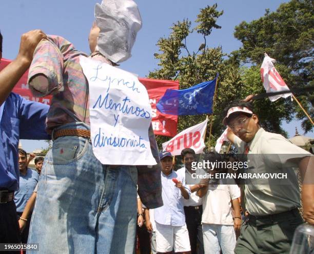 Workers from the education sector hold up a doll to reprent the minister of education during a protest in Lima, Peru 14 may 2002. AFP PHOTO/EITAN...