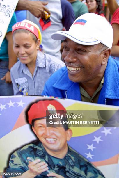 Man with a photograph of president Hugo Chavez celebrates in the Miraflores palace in Caracas, 14 April 2002, after Chavez returned to the...