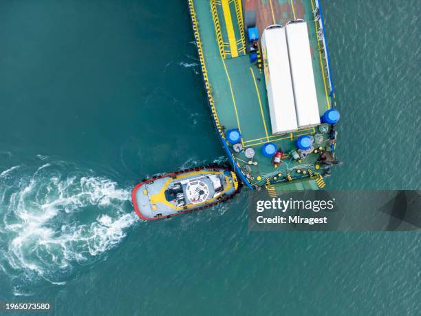 el remolcador acompaña al buque de carga cuando ingresa al puerto. - remolcador fotografías e imágenes de stock