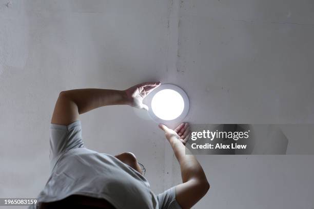 handyman - installing ceiling light fixture stock pictures, royalty-free photos & images