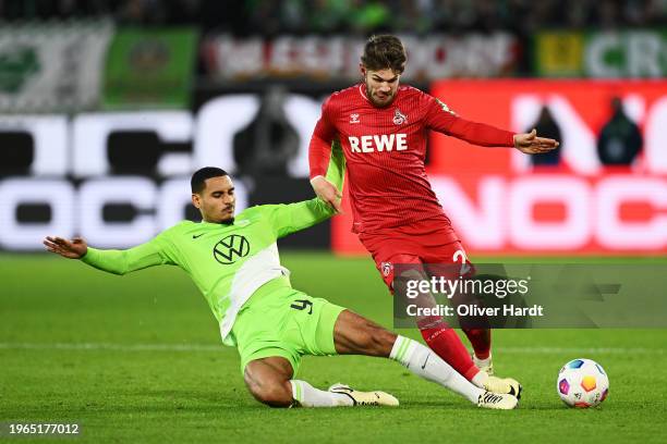 Jan Thielmann of 1.FC Köln is challenged by Maxence Lacroix of VfL Wolfsburg during the Bundesliga match between VfL Wolfsburg and 1. FC Köln at...