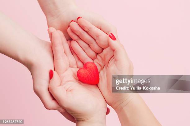 adult and child hands holding red heart,health care, donate and family insurance concept,world heart day, world health day - world aids day stock pictures, royalty-free photos & images