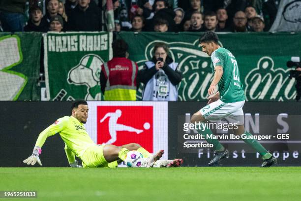 Julian Malatini of Bremen scores his team's third goal against Noah Atubolu of Freiburgduring the Bundesliga match between SV Werder Bremen and...