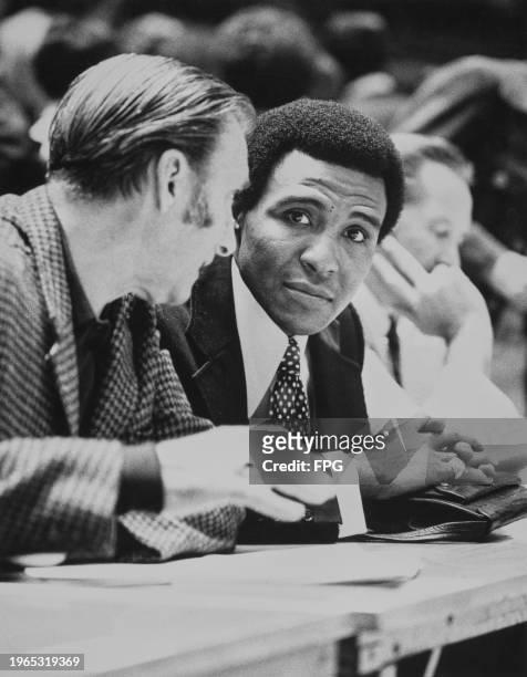American basketball player Jo Jo White, Boston Celtics point guard, in conversation with another man at Madison Square Garden in Midtown Manhattan,...
