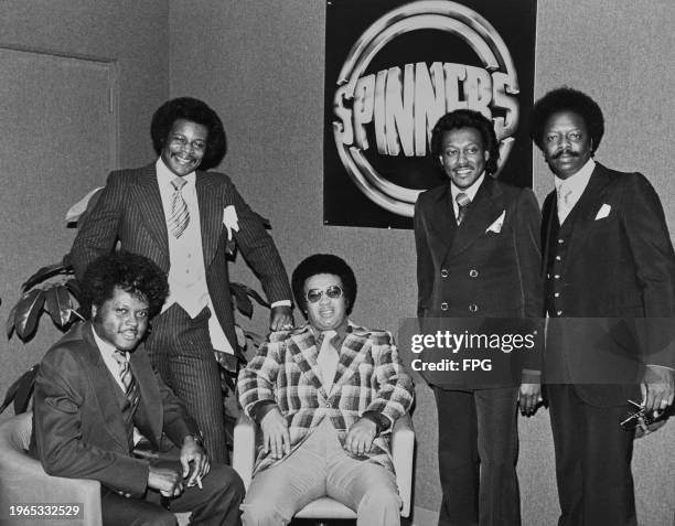 American vocal group The Spinners , pose with an image of the band's album '8' on the wall, United States, circa 1977.